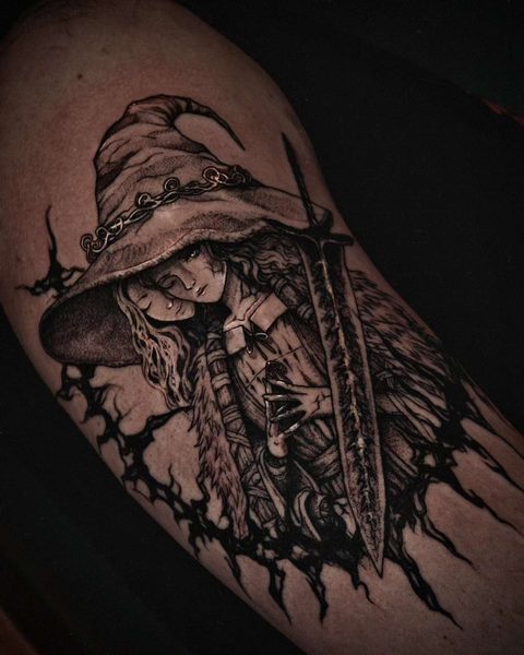 Tattoo of a witch in a wide-brimmed hat, framed by a ring of black thorns